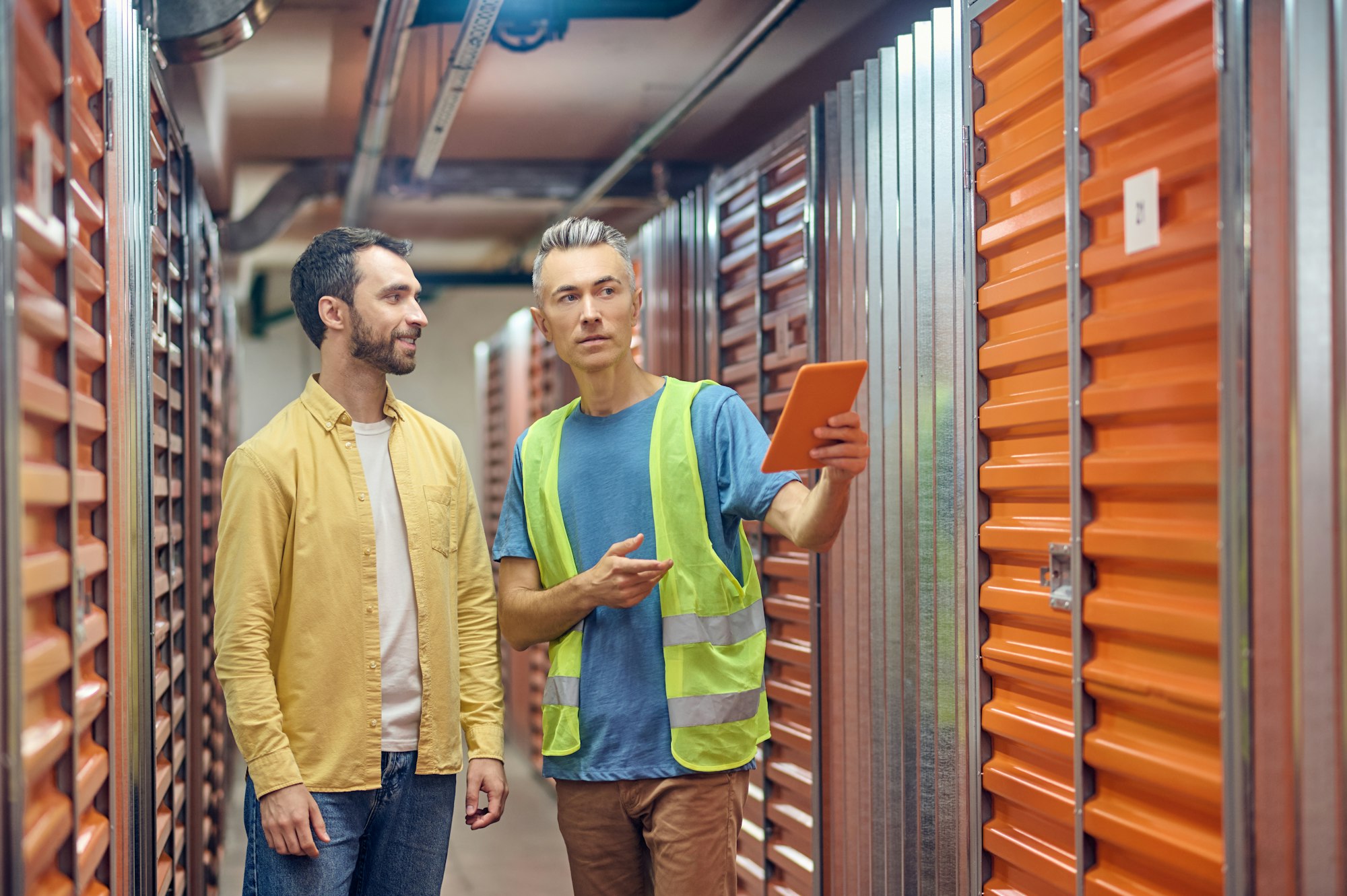 Smiling shopper and warehouse worker pointing to garage